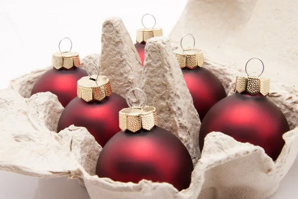 Seis caixa de embalagem de ovos com bolas de Natal vermelho isolado no fundo branco — Fotografia de Stock