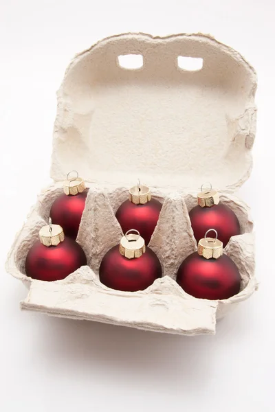 Coffret de six œufs avec boules de Noël rouges isolées sur fond blanc — Photo