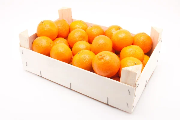 Wodden krabice plné mandarinky na bílém pozadí — Stock fotografie