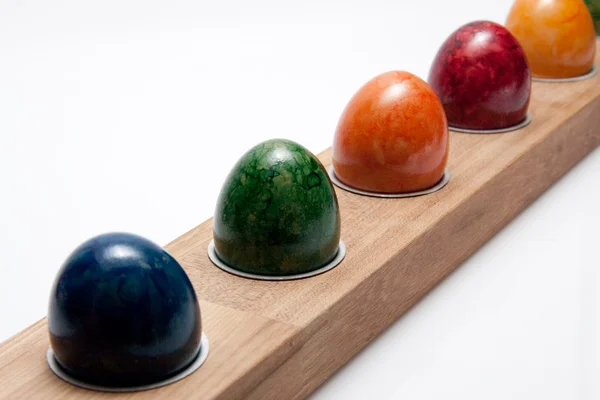 Řádek barevné velikonoční vejce na bílém pozadí — Stock fotografie