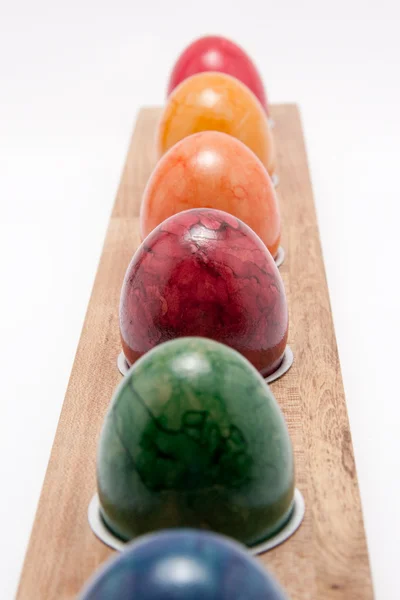 Riga di uova di Pasqua colorate su sfondo bianco — Foto Stock