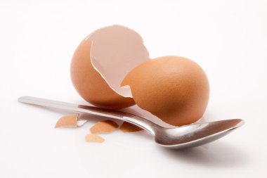 Beyaz arka plan üzerinde izole kaşıkla yumurta kabuğu