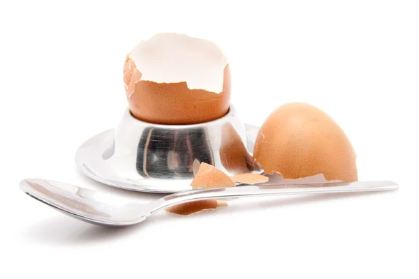 Skal av ett ägg med sked och äggkopp isolerad på vit bakgrund — Stockfoto