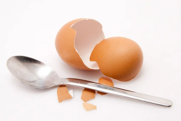 Skal av ett ägg med sked isolerad på vit bakgrund — Stockfoto