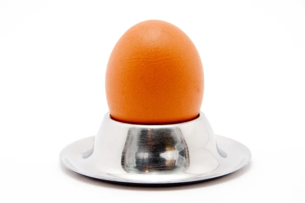 Яйцо с ложкой на белом фоне — стоковое фото