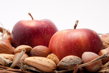 Kırmızı elma ve beyaz arka plan üzerinde izole bir sepet içinde fındık