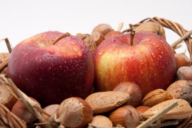 waterdrops ve fındık beyaz zemin üzerine izole bir sepet içinde kırmızı elmalar