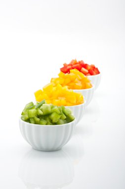 Beyaz arka plan üzerinde izole kase taze yeşil, sarı, turuncu ve kırmızı biber