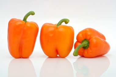 Beyaz arka plan üzerinde izole bir satır turuncu biber