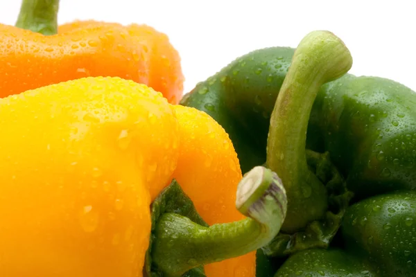 Verse geel, oranje en groene peper met waterdruppels geïsoleerd op witte achtergrond — Stockfoto