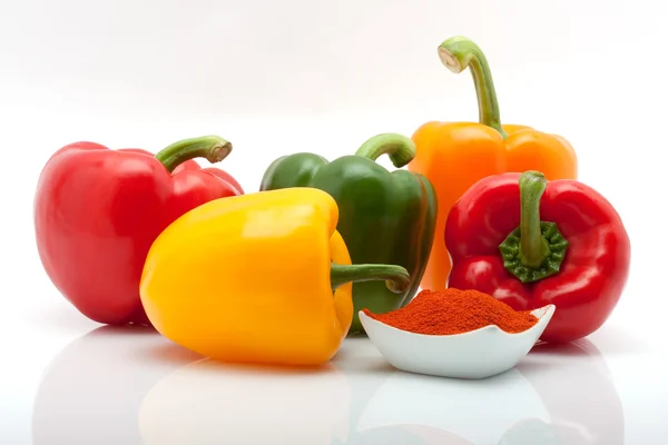 Rode, groene, gele en oranje paprika's en paprika in een schaal geïsoleerd op witte achtergrond — Stockfoto