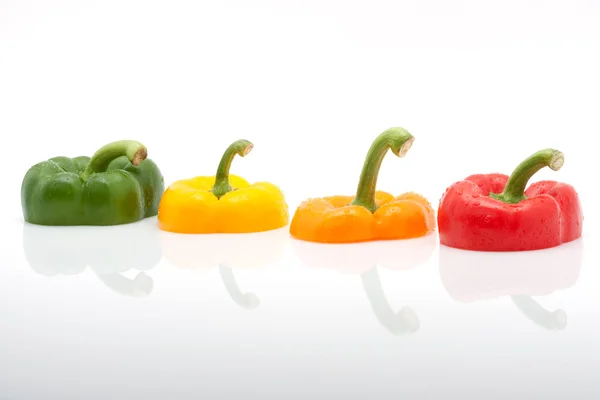 Segmenten van rode, groene, gele en oranje paprika geïsoleerd op witte achtergrond — Stockfoto