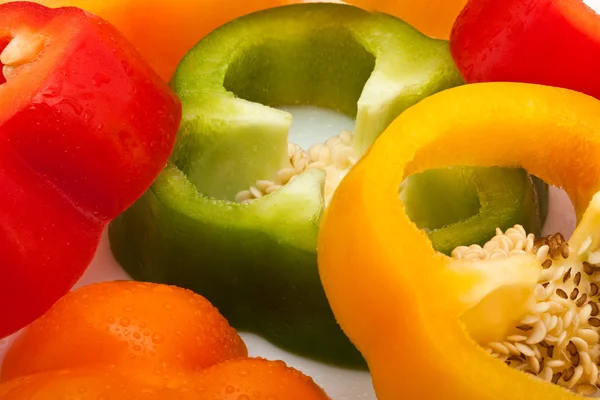 Slices of red, green, yellow and orange pepper isolated on white background — Stock Photo, Image