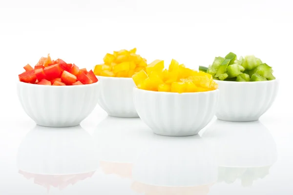 Beyaz arka plan üzerinde izole kase taze yeşil, sarı, turuncu ve kırmızı biber