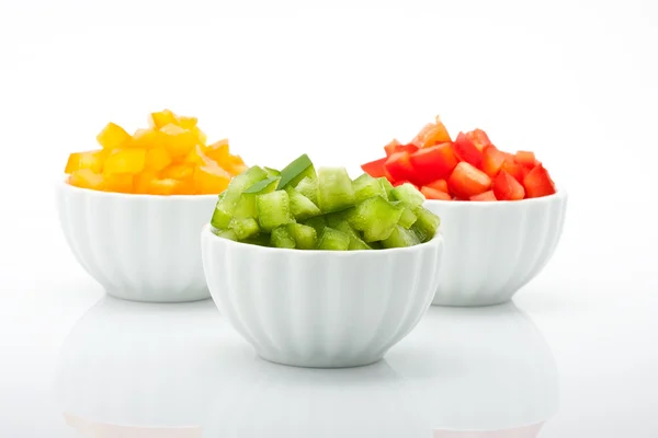 Beyaz arka plan üzerinde izole kase taze yeşil, sarı ve kırmızı biber