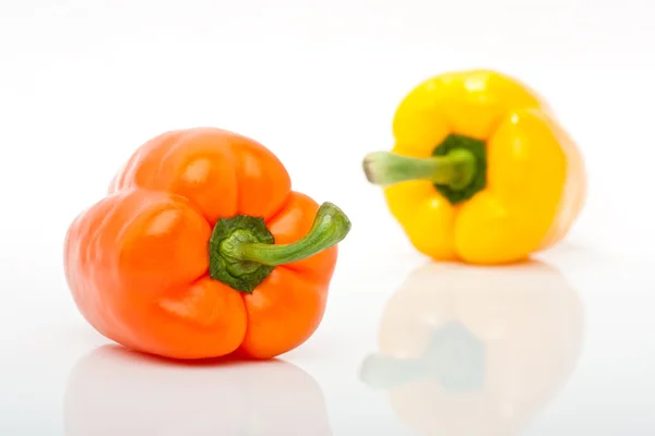 Oranje en gele peper geïsoleerd op witte achtergrond — Stockfoto