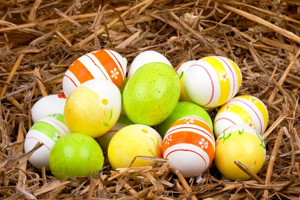 Oeufs de Pâques peints colorés cachés dans un nid de paille — Photo