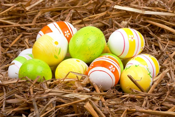 Färgglada målade påskägg gömda i ett bo av halm — Stockfoto