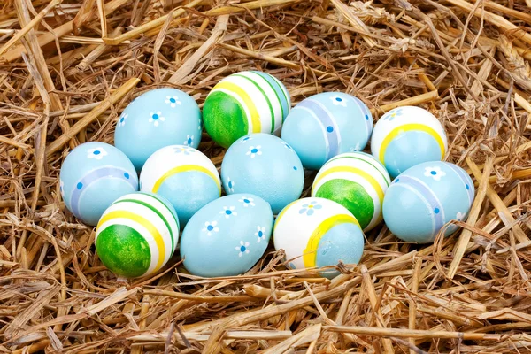 Colorful painted easter eggs hidden in a nest of straw — Stock Photo, Image