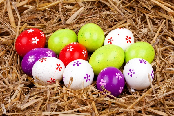 Colorate uova di Pasqua dipinte nascoste in un nido di paglia — Foto Stock