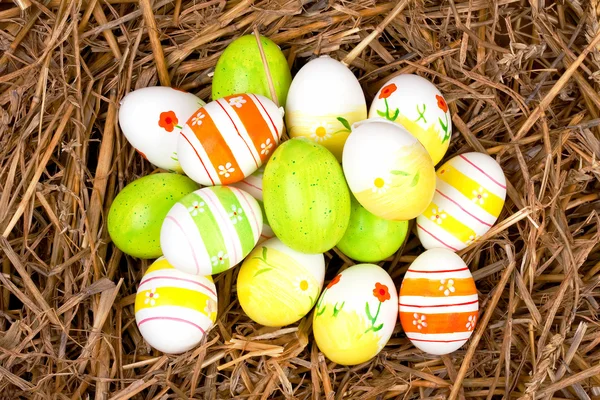 Ovos de páscoa pintados coloridos escondidos em um ninho de palha — Fotografia de Stock