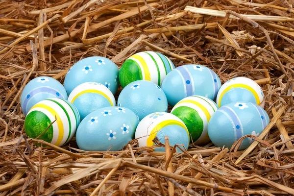 Colorful painted easter eggs hidden in a nest of straw — Stock Photo, Image