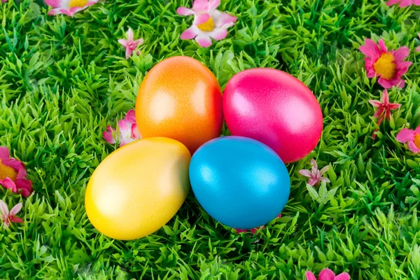 Coloridos huevos de Pascua pintados ubicados en un prado con flores —  Fotos de Stock