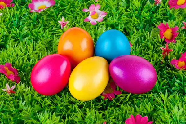 Coloridos huevos de Pascua pintados ubicados en un prado con flores —  Fotos de Stock