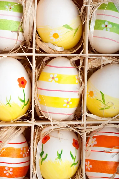 Assorted colorful painted easter eggs in a wooden box — Stock Photo, Image