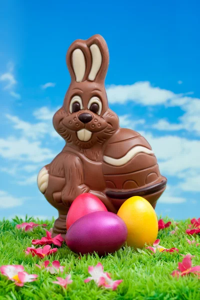 Paskalya tavşanı çikolata Paskalya yumurta yeşil çayır çiçekler önünde mavi gökyüzü ile yapılan