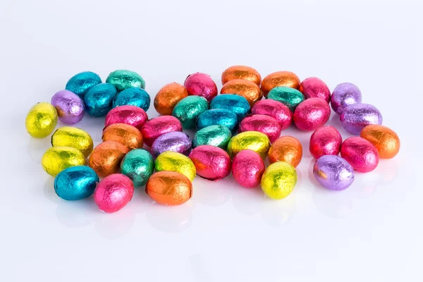 Paashaas gemaakt van chocolade met easter egg op een groene weide met bloemen voor een blauwe hemel — Stockfoto