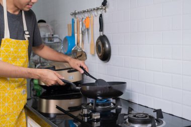 Asyalı şef tavada yumurta kızarttı, Tayland yemeği ocakta, tavada yağ kaynadı, yumurta ve domuz eti pişirildi. Mutlu bir aileye hizmet etmeden önce evde birlikte yemek yemek için.