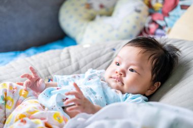 Asyalı yeni doğmuş bebek anne ile göz teması yumuşak yatak metaforunda mutlu aileleri olan çocukların tatlılığı anne ve bebek için bebek ürünleri üreten sağlıklı yaşam tarzı.