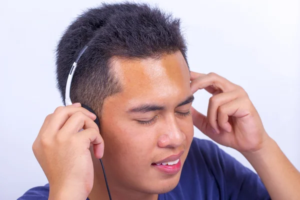 Close up van een jonge jongen gezicht luisteren naar muziek met koptelefoon — Stockfoto