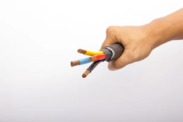 Hand som håller en tre-fas-spänning el-kabel Stockfoto