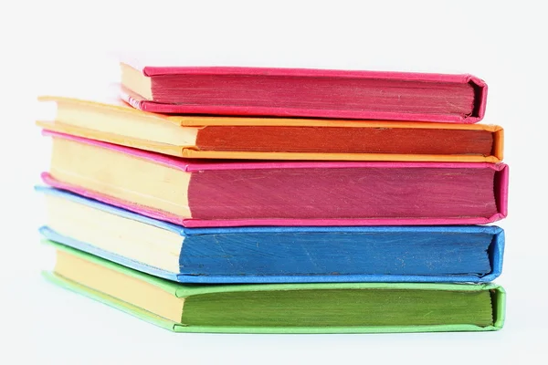 Pila di libri lucenti sopra bianco — Foto Stock