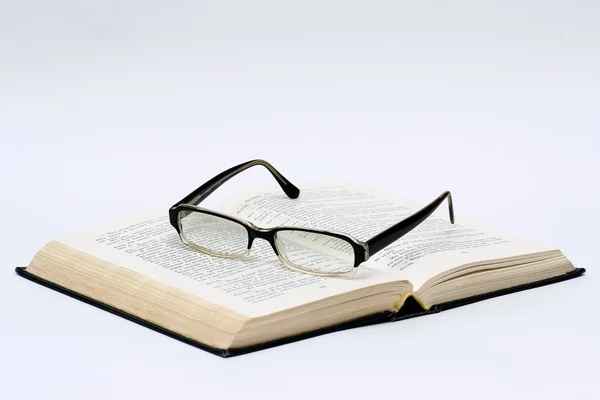 Black glasses and book over white — Stock Photo, Image