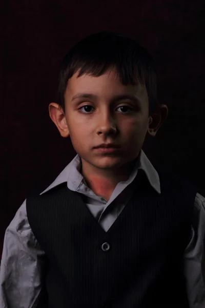 Allvarlig pojke på brun bakgrund — Stockfoto