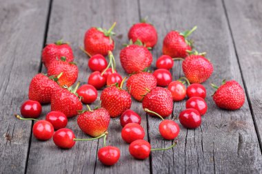 çilek ve vişne eski ahşap zemin üzerinde