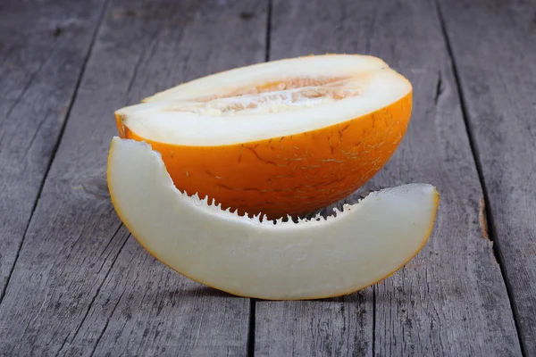 Sliced melon on old wood background — Stock Photo, Image