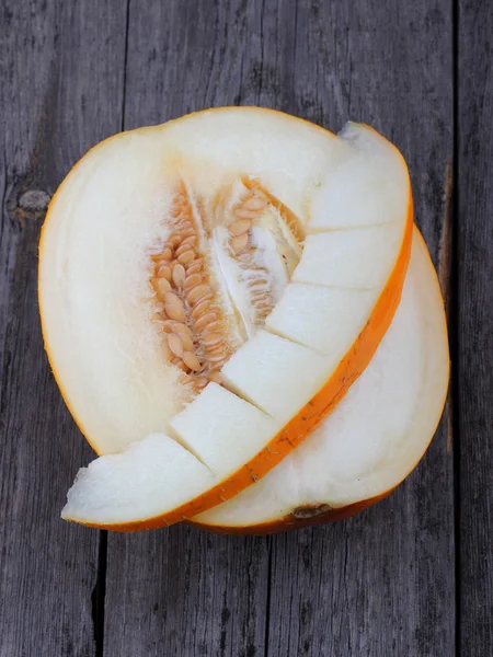 Melon tranché sur un vieux fond de bois — Photo