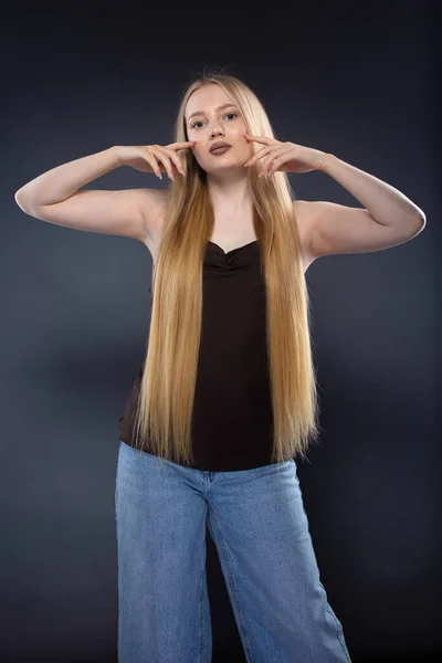 Jeune Femme Blonde Jeans Singulet Brun Sur Fond Gris Foncé — Photo