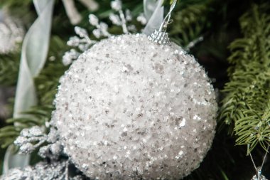 Dala asılı gümüş bir Noel ağacı oyuncağının yakın plan görüntüsü. Madalyalı Noel ağacı.