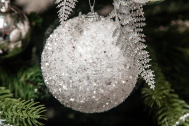 Dala asılı gümüş bir Noel ağacı oyuncağının yakın plan görüntüsü. Madalyalı Noel ağacı.