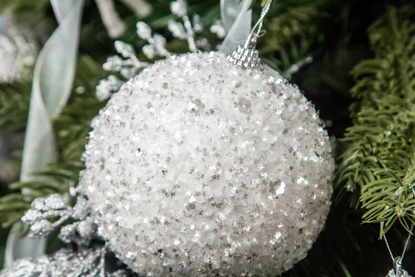 Dala asılı gümüş bir Noel ağacı oyuncağının yakın plan görüntüsü. Madalyalı Noel ağacı.