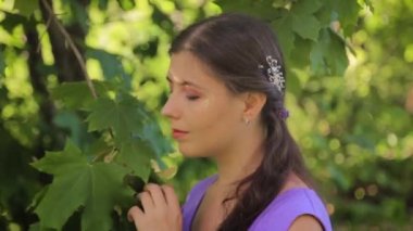 Ortaçağ elbisesiyle Bokeh Park 'ın arka planında makyajlı çekici genç bir kadının portresi..