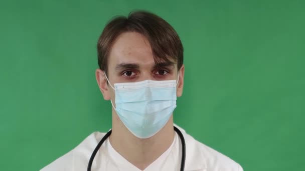 身穿白衣 戴着面具 戴着手套的医生手里拿着注射器 手里拿着疫苗 在绿色的屏幕上做着一个孤立的大拇指手势 键入的色谱关键背景 — 图库视频影像