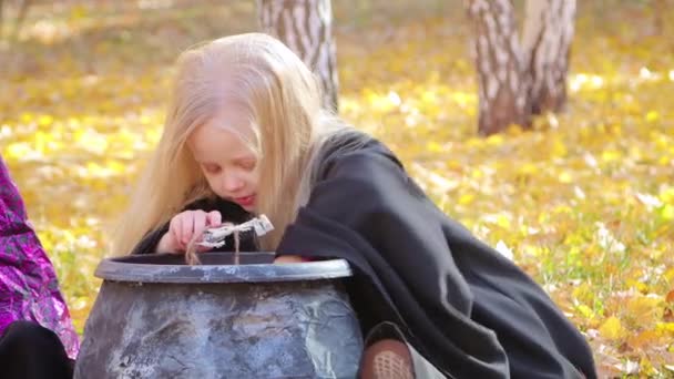 Uma Menina Manto Preto Tira Caldeirão Esqueletos Brinquedo Forca Sentado — Vídeo de Stock