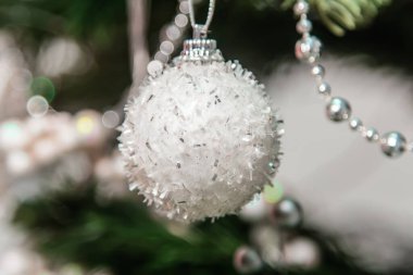 Dala asılı gümüş bir Noel ağacı oyuncağının yakın plan görüntüsü. Madalyalı Noel ağacı.