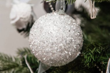 Dala asılı gümüş bir Noel ağacı oyuncağının yakın plan görüntüsü. Madalyalı Noel ağacı.